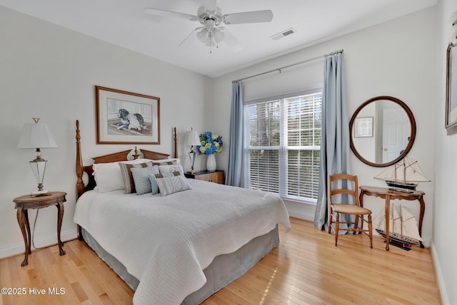 bedroom with light wood finished floors, a ceiling fan, visible vents, and baseboards