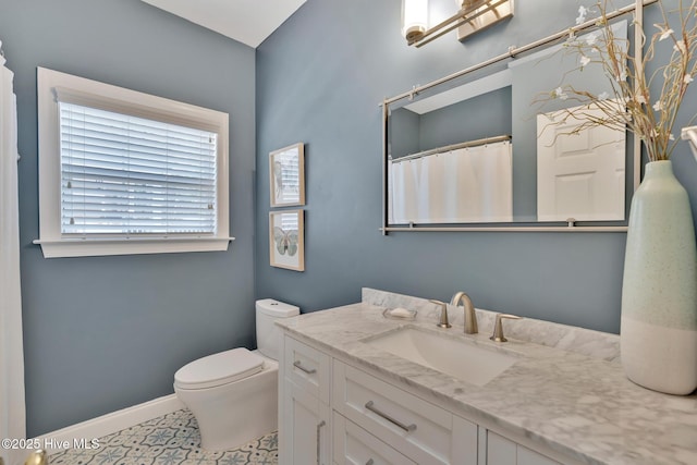 full bathroom featuring toilet, vanity, and baseboards