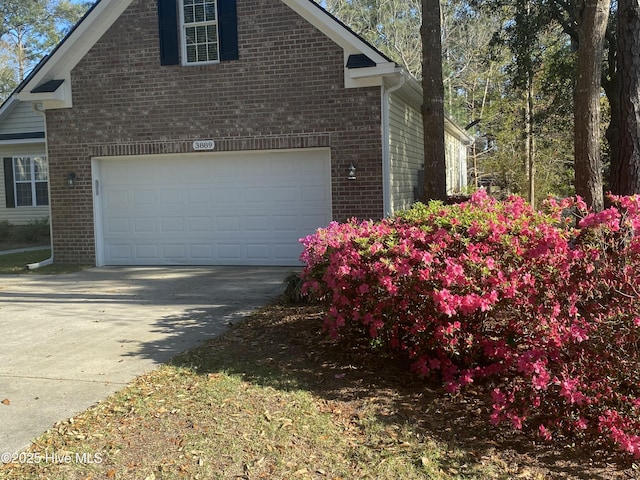 view of home's exterior featuring driveway and brick siding