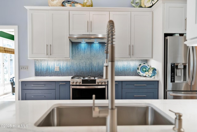 kitchen featuring under cabinet range hood, white cabinets, light countertops, appliances with stainless steel finishes, and backsplash