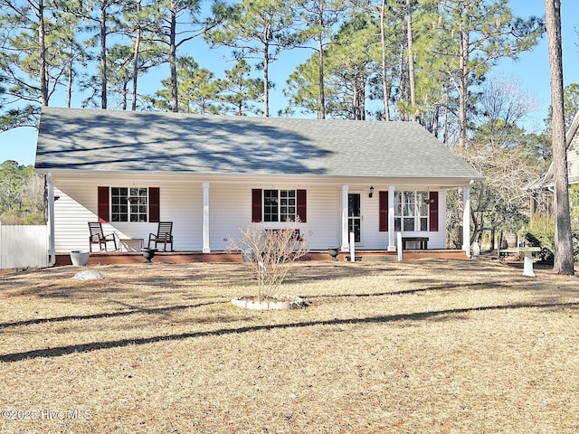 view of front facade featuring a porch, a front yard, and roof with shingles