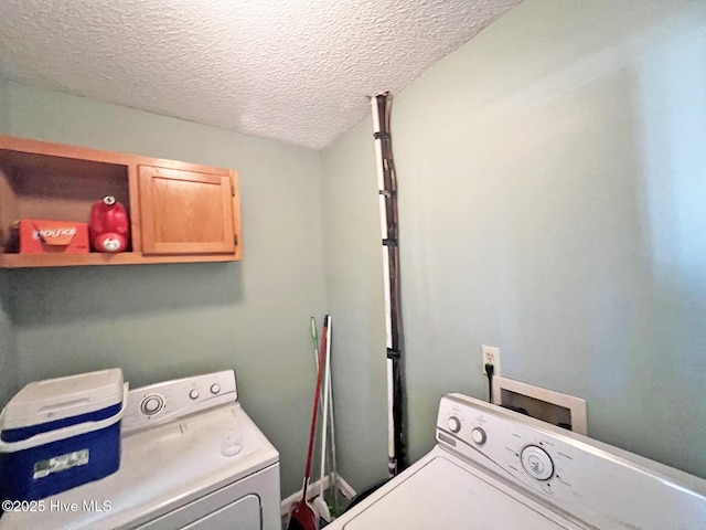 washroom with a textured ceiling, washing machine and clothes dryer, and cabinet space