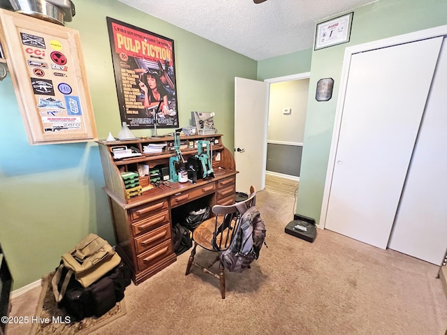 carpeted home office with a textured ceiling