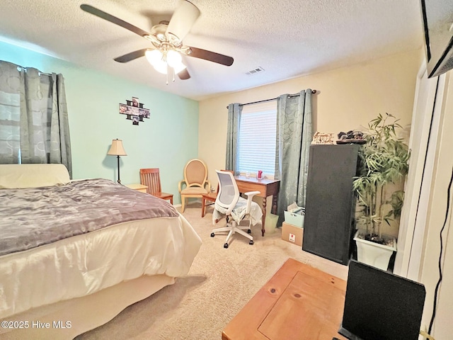 carpeted bedroom with a textured ceiling, ceiling fan, and visible vents