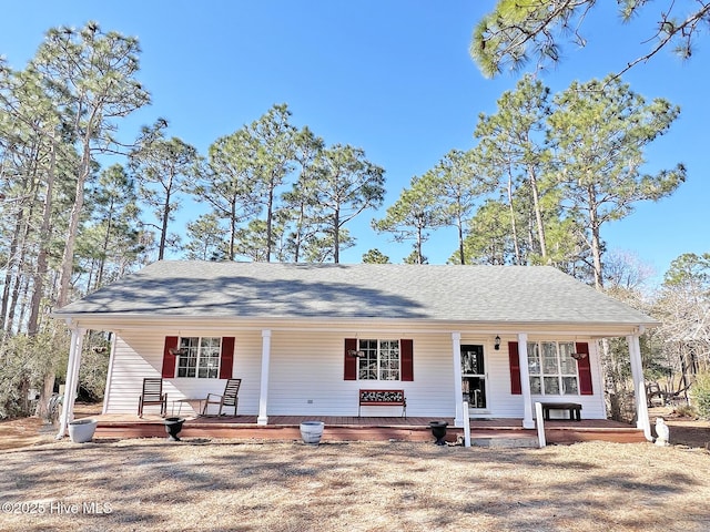 single story home with covered porch and roof with shingles