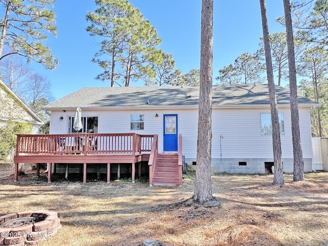 back of property with an outdoor fire pit, a shingled roof, stairway, crawl space, and a wooden deck