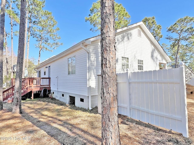 rear view of property with stairway, fence, and a deck