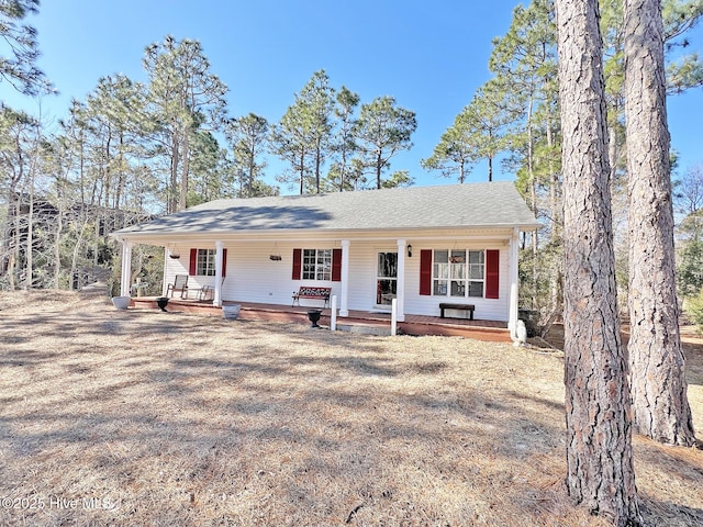 view of front of property featuring a shingled roof and a porch