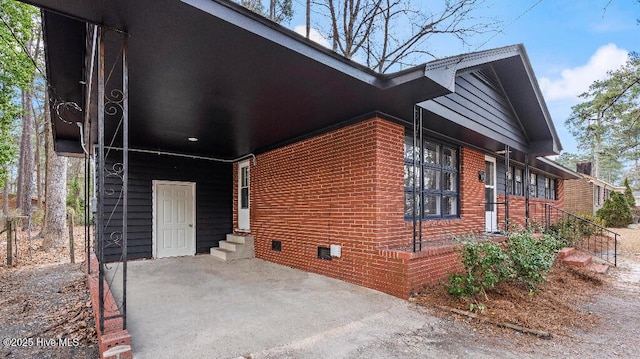 view of property exterior featuring crawl space, entry steps, and brick siding