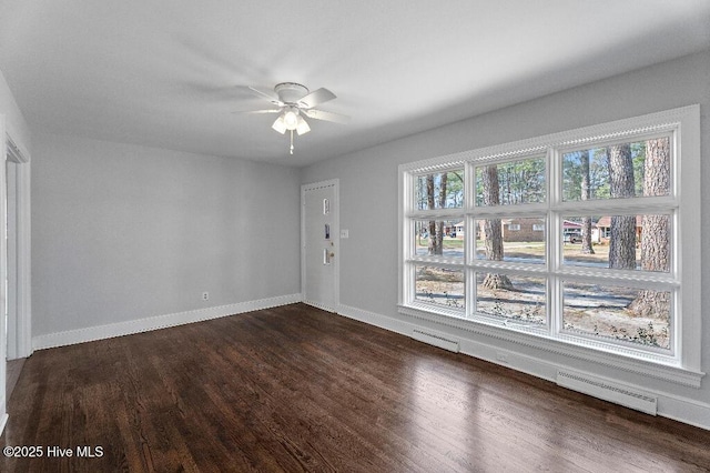 spare room with dark wood-type flooring, visible vents, and baseboards