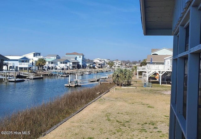 dock area with a water view, a residential view, and a lawn