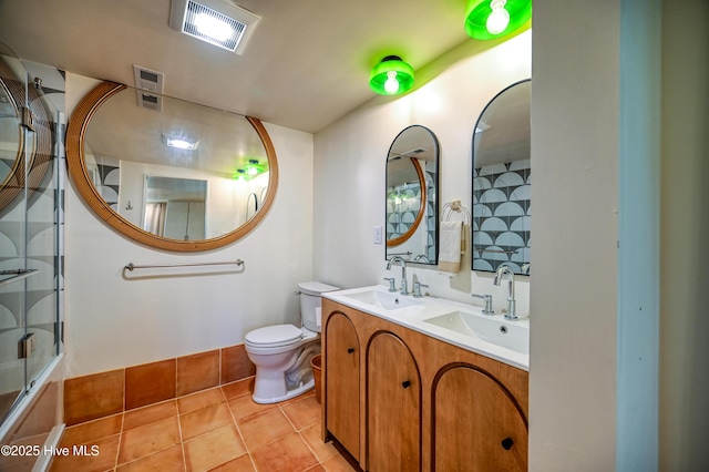 2121 Gibson Ave, Wilmington, NC 28403 - bathroom featuring a shower with shower door, tile patterned floors, double vanity, and toilet