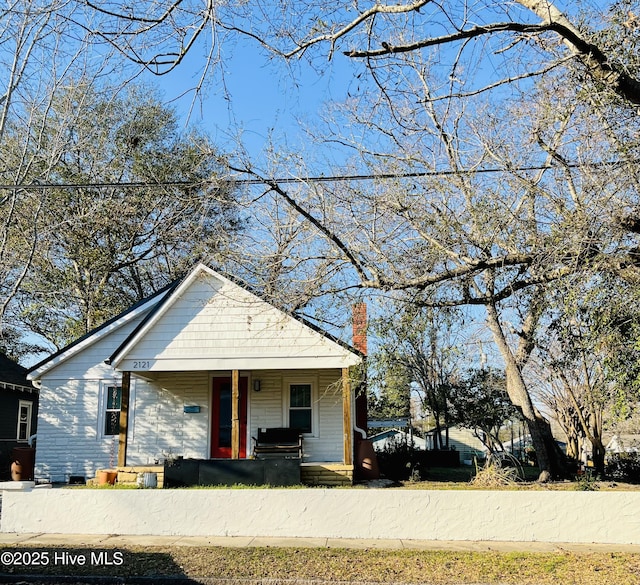 bungalow with covered porch and a chimney