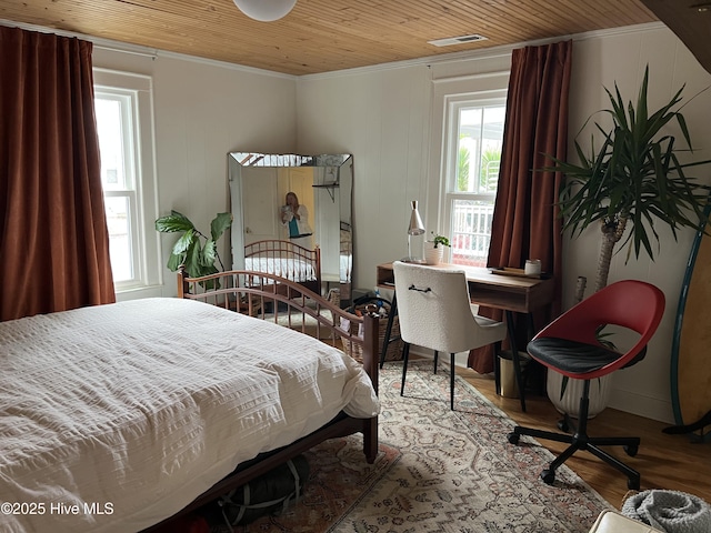 bedroom with visible vents, ornamental molding, wood finished floors, and wood ceiling