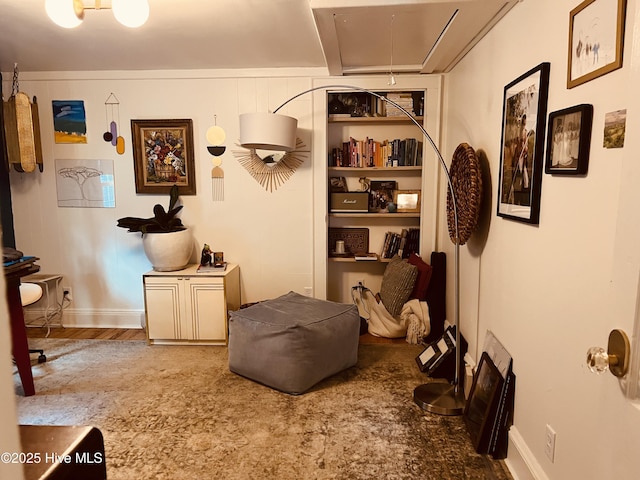 sitting room with wood finished floors, attic access, and baseboards