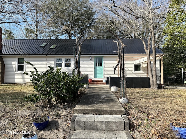 view of front of home with entry steps and metal roof