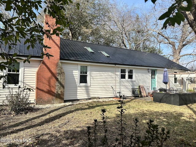 back of house with a patio area, metal roof, and a lawn