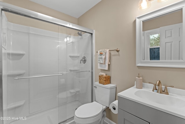 full bath featuring a stall shower, toilet, and vanity