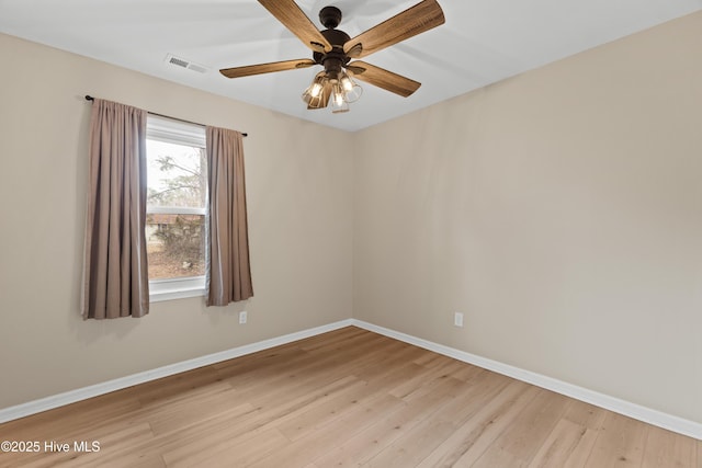 empty room with visible vents, light wood-type flooring, and baseboards