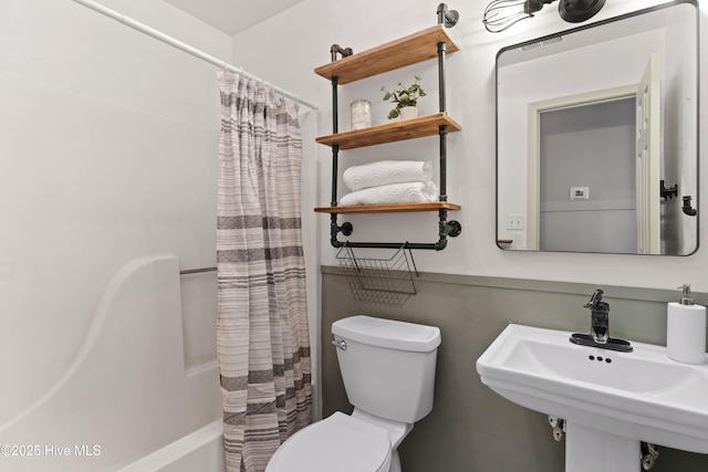 full bath with shower / tub combo, toilet, and a sink