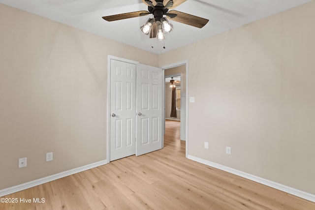 unfurnished bedroom featuring a ceiling fan, baseboards, and light wood-type flooring