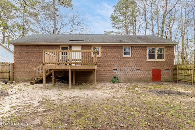 rear view of property featuring crawl space, brick siding, and fence