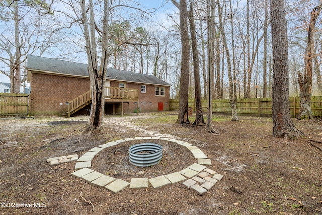 view of yard with stairs, a deck, and fence