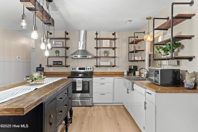 kitchen featuring open shelves, wooden counters, appliances with stainless steel finishes, and wall chimney exhaust hood