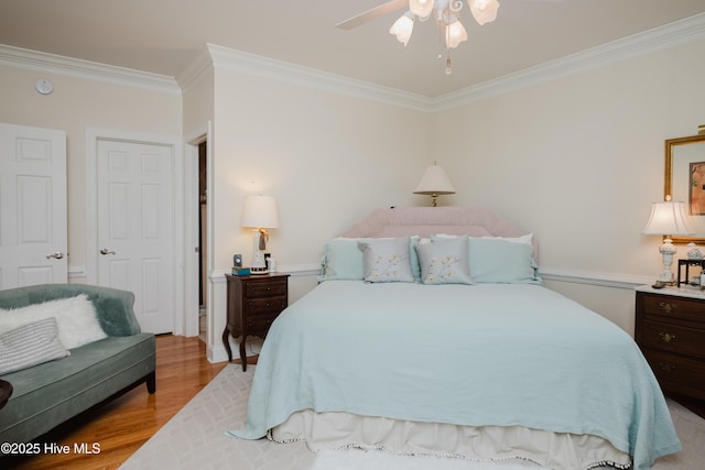 bedroom with crown molding and light wood finished floors