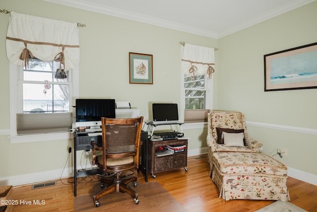 office space featuring crown molding, visible vents, baseboards, and wood finished floors