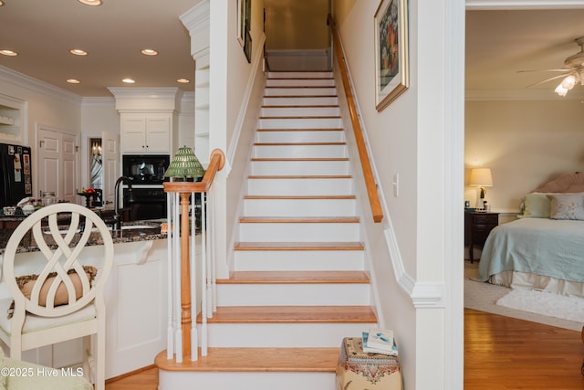 stairway featuring recessed lighting, wood finished floors, a ceiling fan, and crown molding