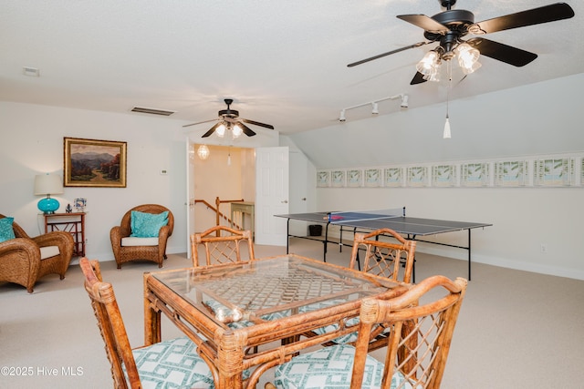 dining area with light carpet, vaulted ceiling, visible vents, and baseboards