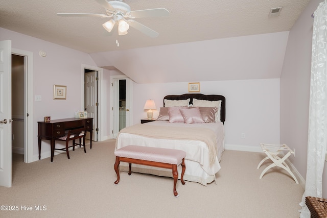 bedroom with baseboards, light colored carpet, lofted ceiling, ceiling fan, and a textured ceiling