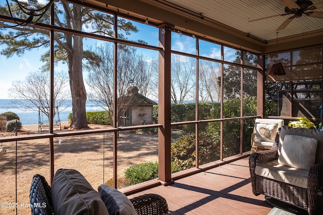 sunroom / solarium with a water view and a ceiling fan