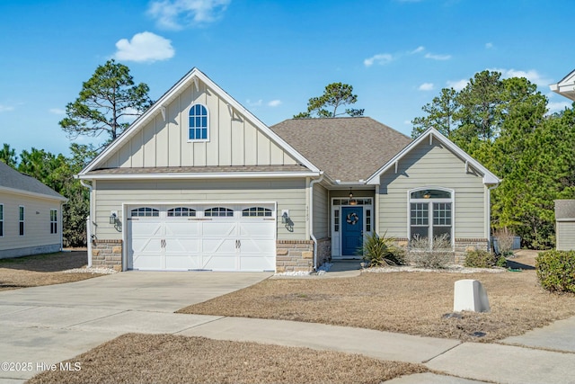 craftsman inspired home with a garage, concrete driveway, stone siding, roof with shingles, and board and batten siding