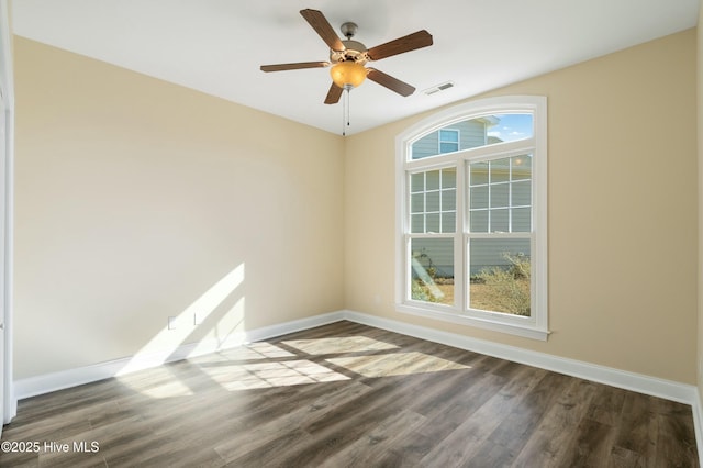 empty room featuring a wealth of natural light, visible vents, and baseboards