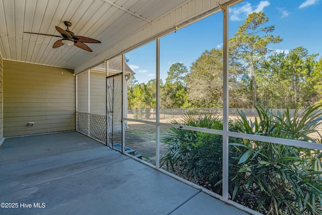 unfurnished sunroom featuring wood ceiling and a ceiling fan