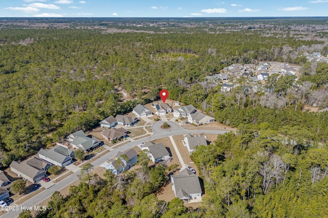 drone / aerial view featuring a residential view and a view of trees