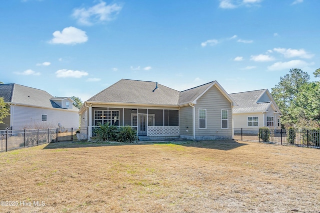 rear view of property featuring a shingled roof, a lawn, a fenced backyard, and a sunroom