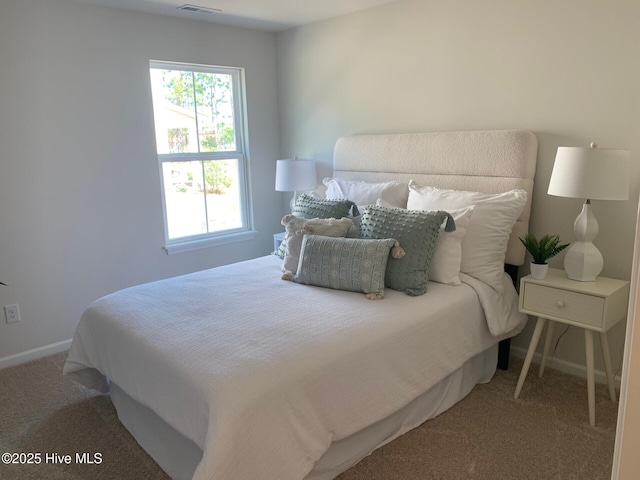 carpeted bedroom with visible vents and baseboards