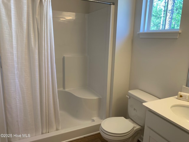 bathroom with toilet, vanity, and a shower with curtain