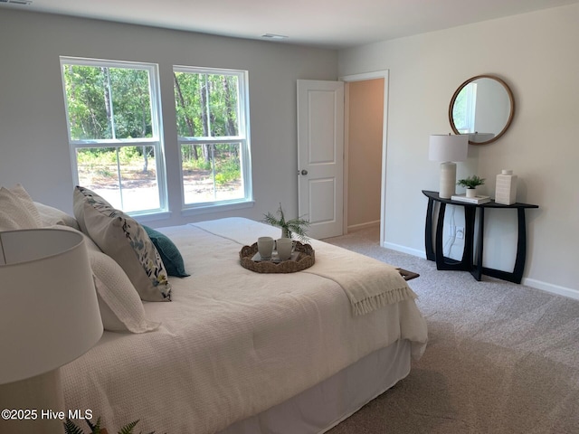 bedroom with light carpet, visible vents, and baseboards