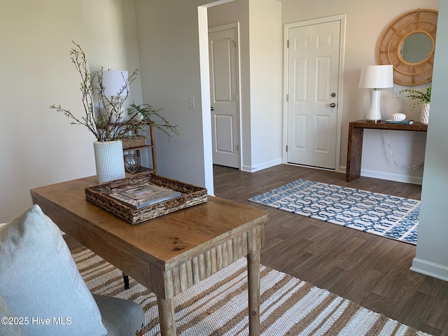 foyer entrance featuring dark wood finished floors and baseboards