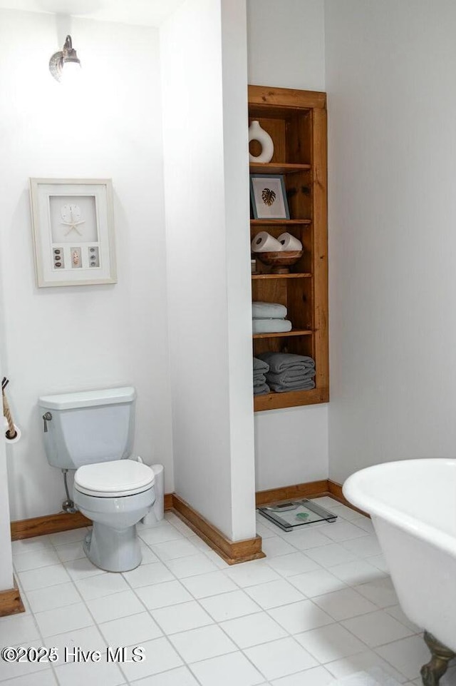 bathroom featuring built in features, toilet, a freestanding bath, and baseboards