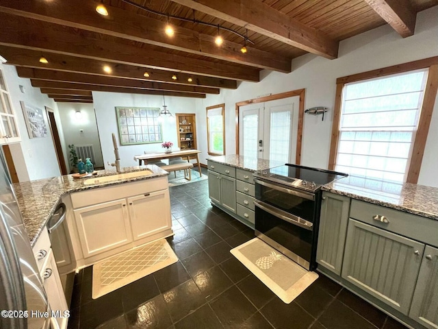 kitchen featuring range with two ovens, wooden ceiling, beamed ceiling, light stone countertops, and french doors