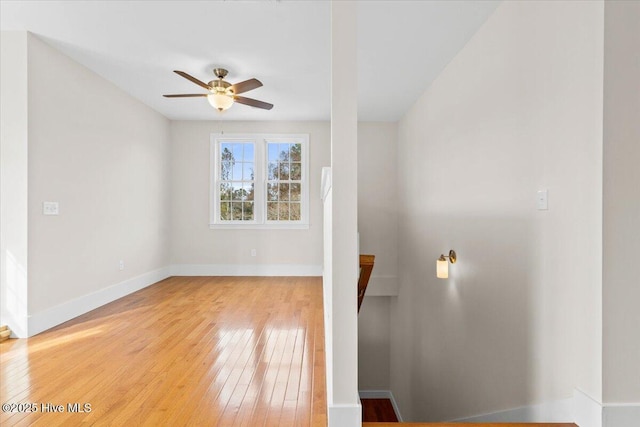 unfurnished living room with ceiling fan, baseboards, and hardwood / wood-style flooring