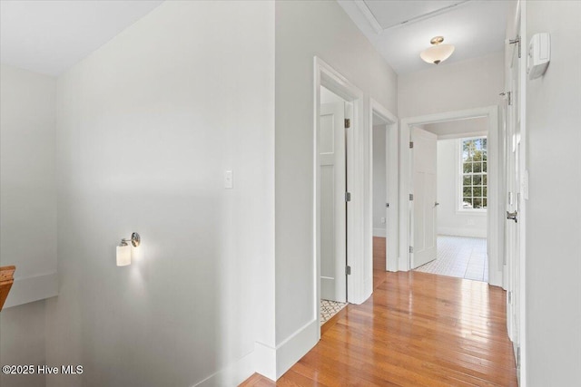 hallway with light wood-style floors and baseboards