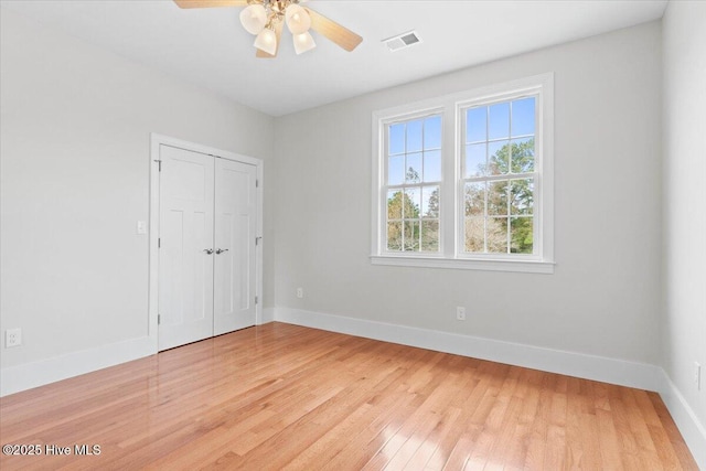 unfurnished bedroom featuring light wood-style floors, a closet, visible vents, and baseboards