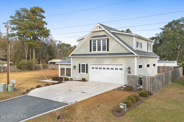 view of front of home featuring an attached garage, concrete driveway, a front yard, and fence