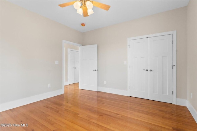 unfurnished bedroom featuring light wood-style flooring, baseboards, ceiling fan, and a closet